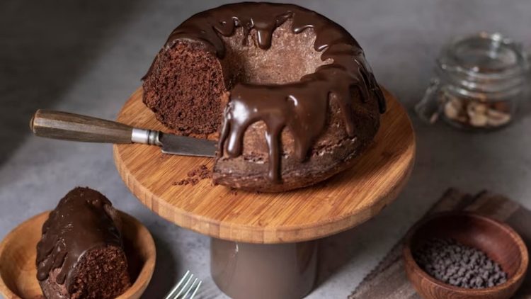 Bolo de chocolate com cobertura cortado em tábua de madeira