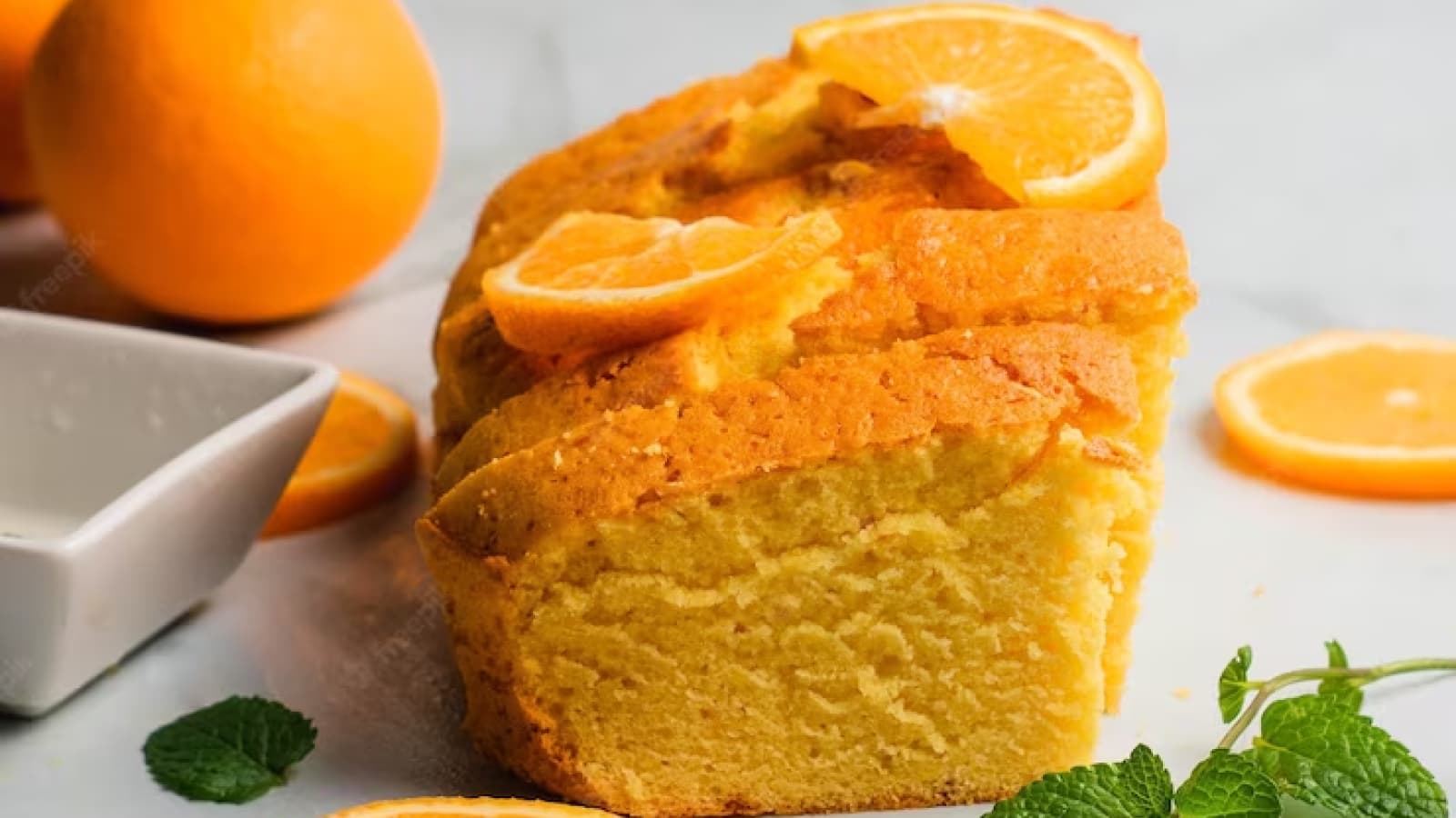 bolo de laranja em cima da mesa com uma rodelas de laranja