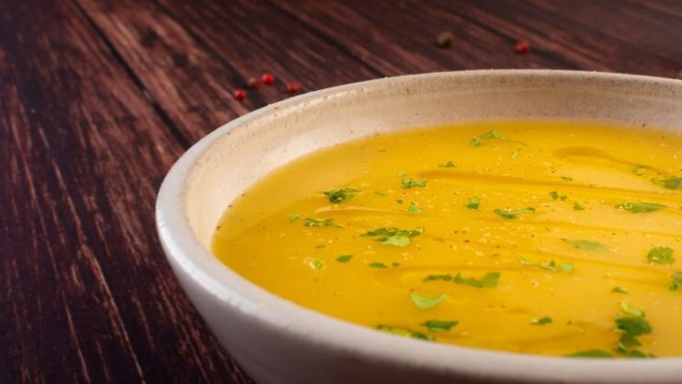 Caldo de mandioca em um prato fundo branco